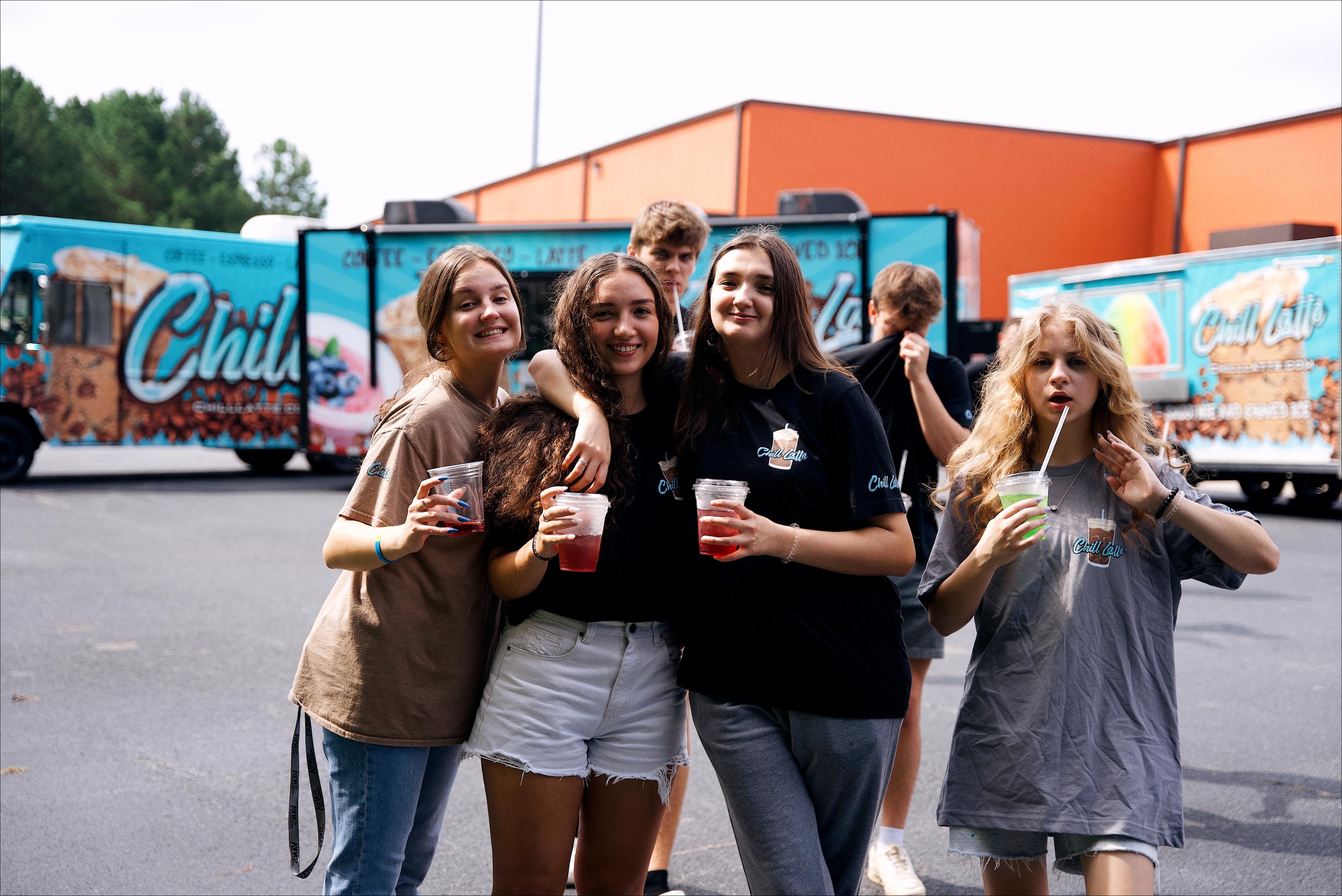 ladies baristas posing near coffee truck 