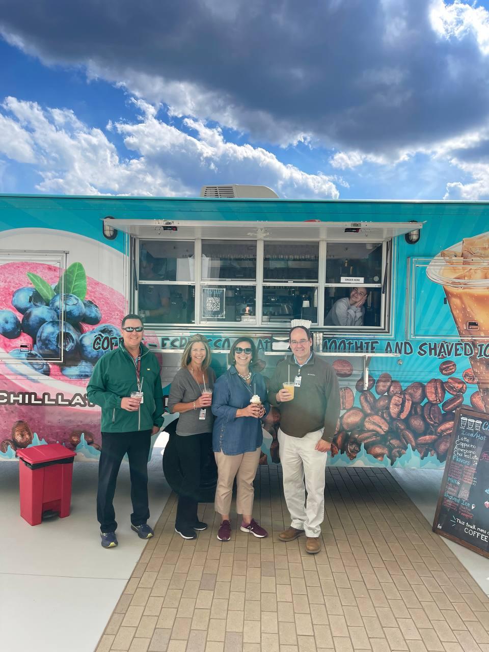 teachers are posing with coffee in their hands in front of the Chill Latte coffee truck 