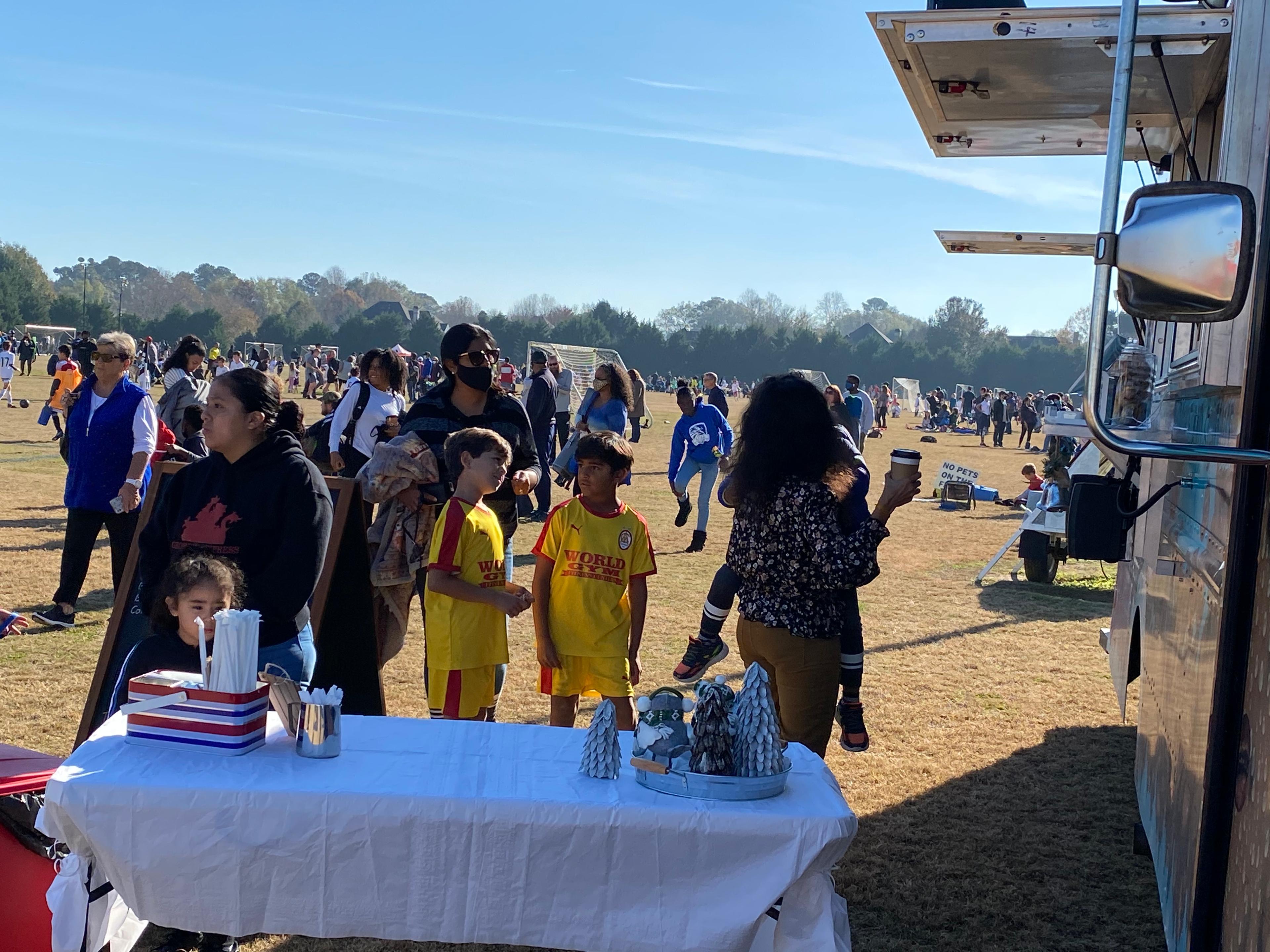 soccer kids ordering hot chocolate at soccer tournament during holiday season 